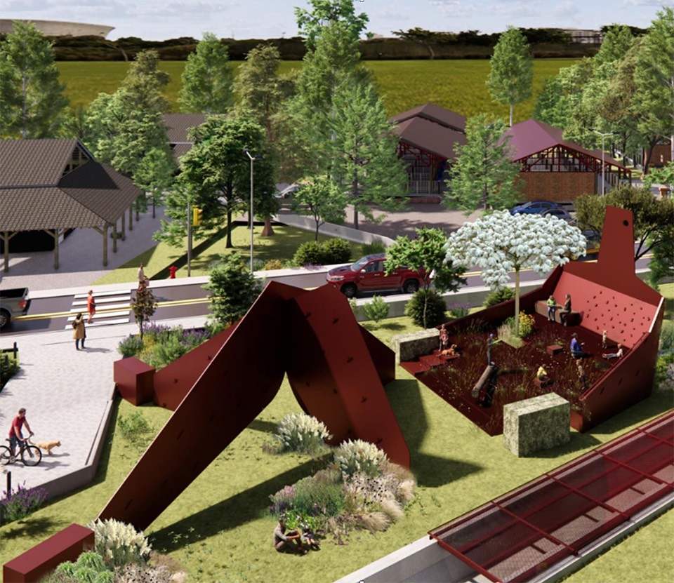 3D rendered aerial view of of an architectural sculpture complex showing distinctive red angular mountain-shaped sculpture structure in foreground, with residential buildings, garages, landscaped grounds with flowering trees, walking paths, and parked vehicles set in a green rural landscape.